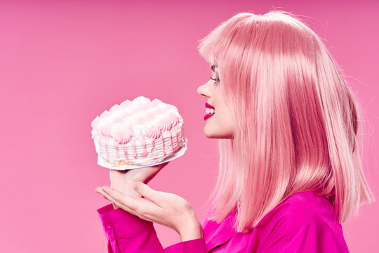 woman with pink hair cake in hands sweets enjoyment isolated background