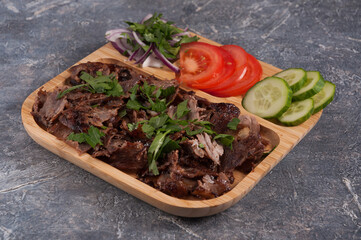 Turkish Doner with veal, cucumbers, tomatoes and onions on a wooden plate