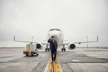 Portrait of happy confident caucasian airplane crew near plane