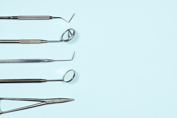 Medical dental instruments on light blue background with copy space. Flat lay closeup top view on...