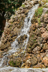 waterfall that flows from a mountain of stones in a park