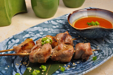 Asian pork skewer on banana leaf with sauce