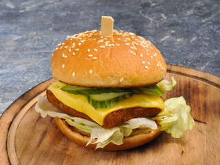 Burger with fish cutlet, cucumber, cheese and lettuce