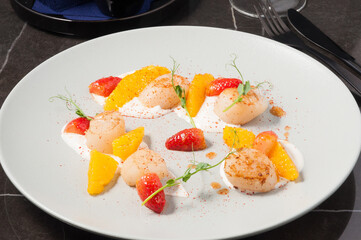 tasty fried scallops with strawberries and orange