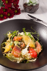 tasty salad with salmon, vegetables and oranges
