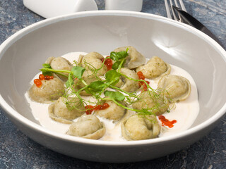 Russian fish dumplings: pike and pike perch in cream sauce, decorated with red caviar