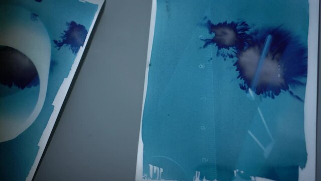 Art printmaking process adding ferric iodide to cyanotype mixture blue color and shake in water