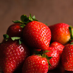 Strawberries macro. Fresh ripe red strawberries on brown background. 