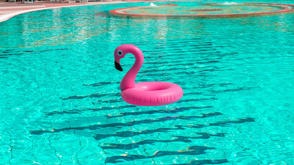 Pink pool. Pink inflatable flamingo in pool water for summer beach background. Pool float party.