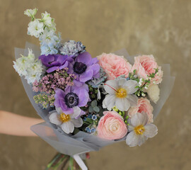 Delicate flower bouquet. Wrapped flowers bouquet. Fresh beautiful flower in hand.