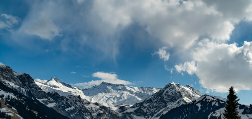 Wildstrubel und Steghorn überragen die Engstligenalp in Adelboden. Schnee von gestern liegt im Frühling auf den Wäldern, Wiesen und Dächern. snowy mountains in Switzerland