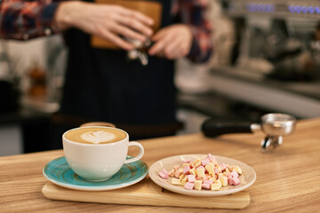 cup of hot drink and marshmallows on table in coffee shop