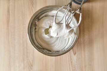 Whipped egg whites and other ingredients for cream on wooden table, closeup