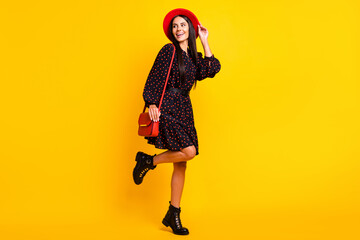 Fototapeta na wymiar Full length photo of pretty cute lady dressed black clothes arm cap handbag looking empty space isolated yellow color background