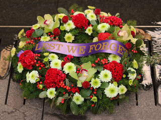 Floral wreath laid at the Royal Australian Regiment Memorial on Anzac Day. Reading "lest we forget"