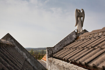 Sculpture of the guardian angel on the roofs of the pantheons in a cemetery, religious concept