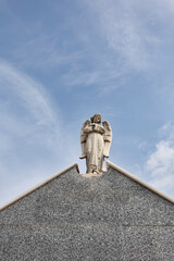 Sculpture of the guardian angel on the roofs of the pantheons in a cemetery, religious concept