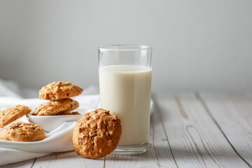 A fresh glass of milk with chocolate chip cookies on white wooden background. Healthy eating. Selective focus.
