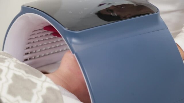 Woman beautician connects and adjusts the device for photo peeling.