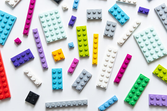 Multicolor plastic blocks on white background. Top view, banner size, many colors.