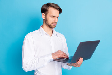 Photo of focused young man look laptop blogger work businessman concentrated face isolated on blue color background