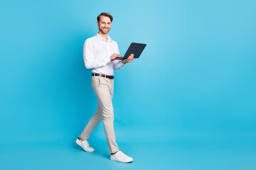 Full length body size view of attractive cheerful skilled man going using laptop isolated over...
