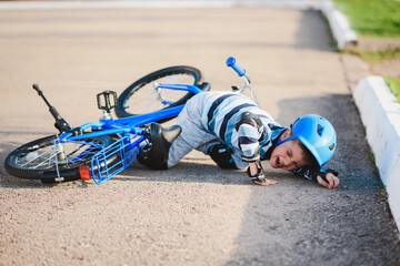 A small child fell from a bicycle onto the road, crying and screaming in pain.