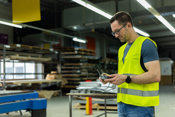 Drohnenpilot an der Fernsteuerung fliegt Inspektionsflug in Fabrikhalle