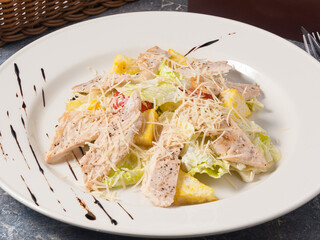 tasty Caesar salad with chicken on a white plate