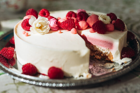 White cake with berries and flower on top