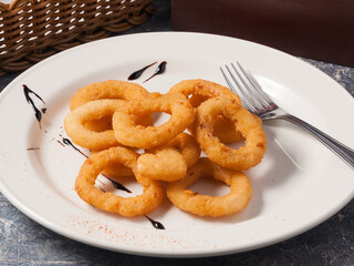 onion rings on a white plate. Concept: snack to beer