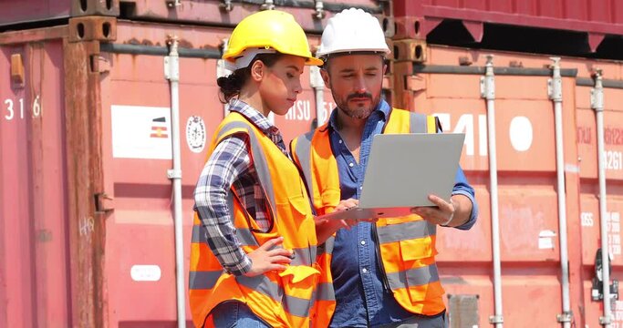 An officer from the Customs Department inspects the cargo in the container yard. Hispanic man worker in hardhat helmet and latin woman foreman worker discuss togetherness at container yard.