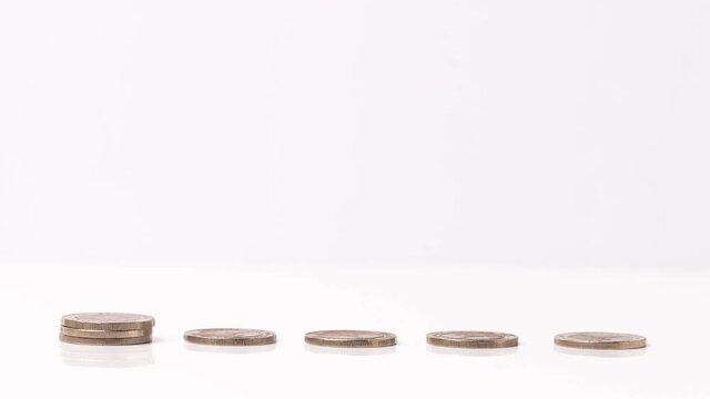 4k stop motion five piles of gold money coins decreasing fading disappear on white background, financial trading concept.