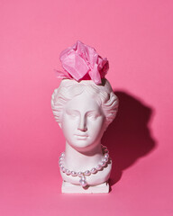 Trendy Venus plaster head planter with paper brain on pink background