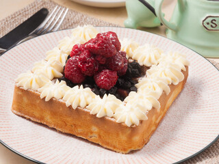Belgian waffle with cream, raspberries and blueberries