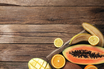 Fresh tropical fruits in a wooden box on a wooden background