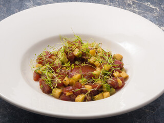 tuna, avocado and mango tartare on a white plate