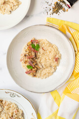 Risotto with mushrooms, green tea and italian speck. White background and yellow towel