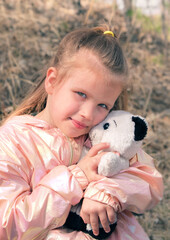 Little girl hugging teddy bear, walking outdoor