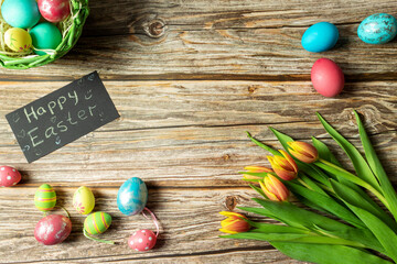 Easter concept, tulips on a wooden table, Easter eggs, top view
