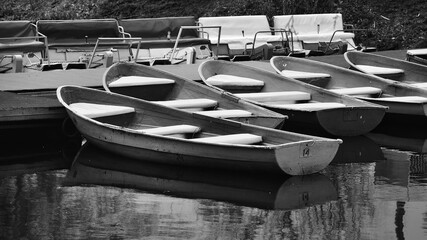 Rowboats on a pond in a public park. Black and white photo. Close-up.