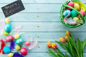 Easter eggs, eggs in a basket on the background of a blue board, top view, the inscription Easter, the word Easter
