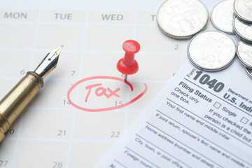 Fototapeta premium tax day concept with red circle on calendar date and tax return on table 