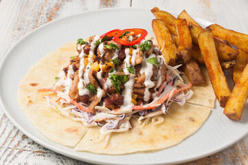 lunch with meat and vegetables on tortillas and French fries