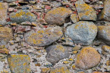 Large stones with small stones and fragments in the masonry wall of a medieval castle.