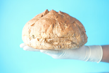 hand holding round brown baked bread