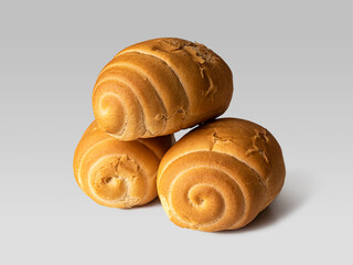 Wheat buns with a golden crust and curls on a light background