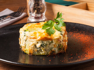 baked broccoli on a black plate in a restaurant. Concept: vegetarian food