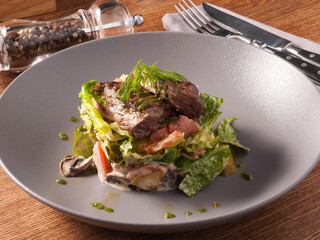 warm salad with veal, vegetables and mushrooms in the restaurant
