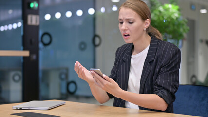 Disappointed Young Businesswoman having Loss on Smartphone 